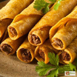 air fryer taquitos stacked on a plate with cilantro garnish
