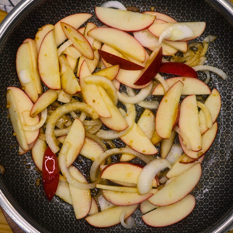Sliced apples and onions in a skillet with minced garlic
