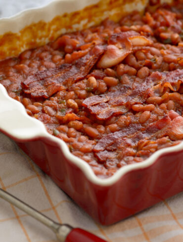 Baked Beans and Bacon in a red baking dish