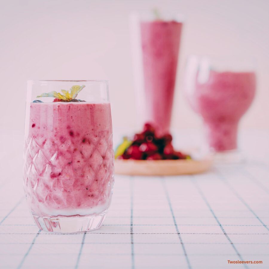 Berry Smoothie in multiple glasses with a pile of mixed berries