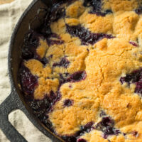Close up image of Blueberry Cobbler in a cast iron pan