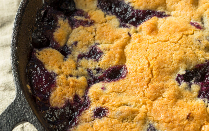 Close up image of Blueberry Cobbler in a cast iron pan