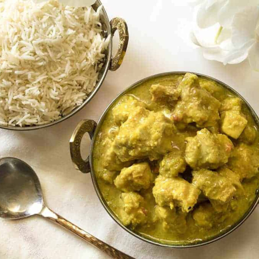 Overhead image of Chicken Korma in a serving dish with rice on the side
