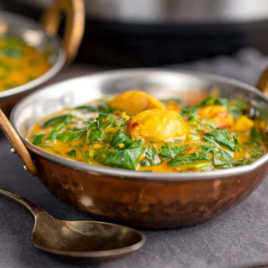 Close up image of Chicken saag in a bowl with a spoon