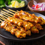 Close up image of Chicken Satay stacked on a plate