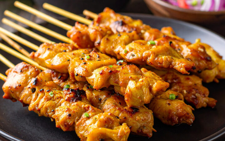 Close up image of Chicken Satay stacked on a plate