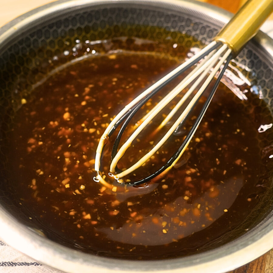 Homemade teriyaki sauce in a pan with a whisk