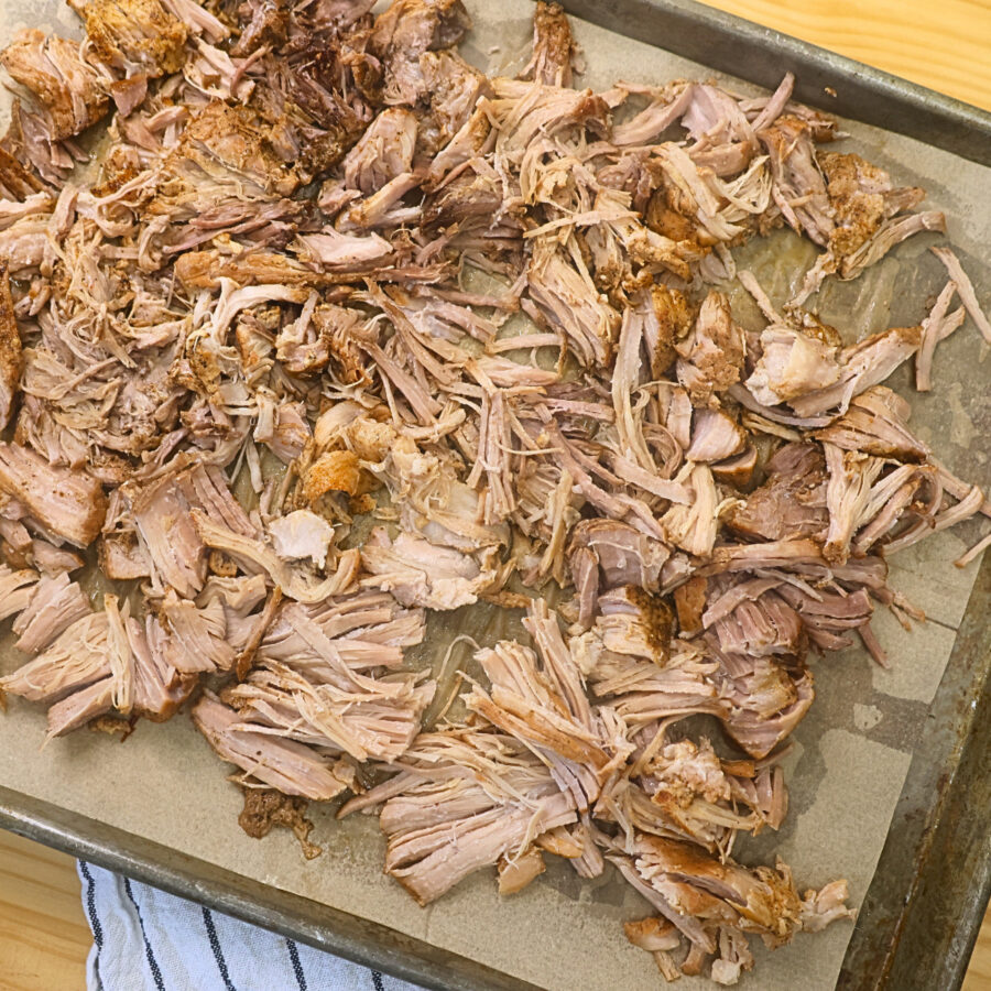 Shredded slow cooked pork on a baking sheet