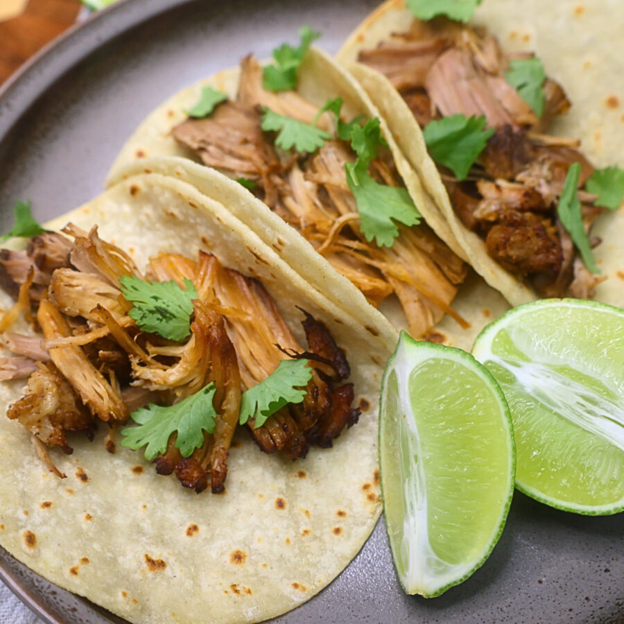 Assembled Chipotle Pork Carnitas on a plate with lime and cilantro