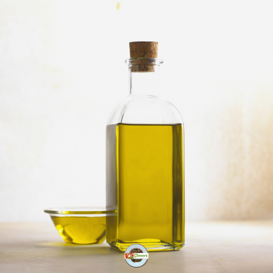 A bottle of cooking oil with a small bowl of oil next to it
