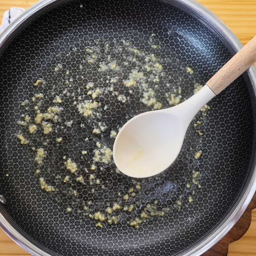 garlic and butter in a large pan with a large spoon