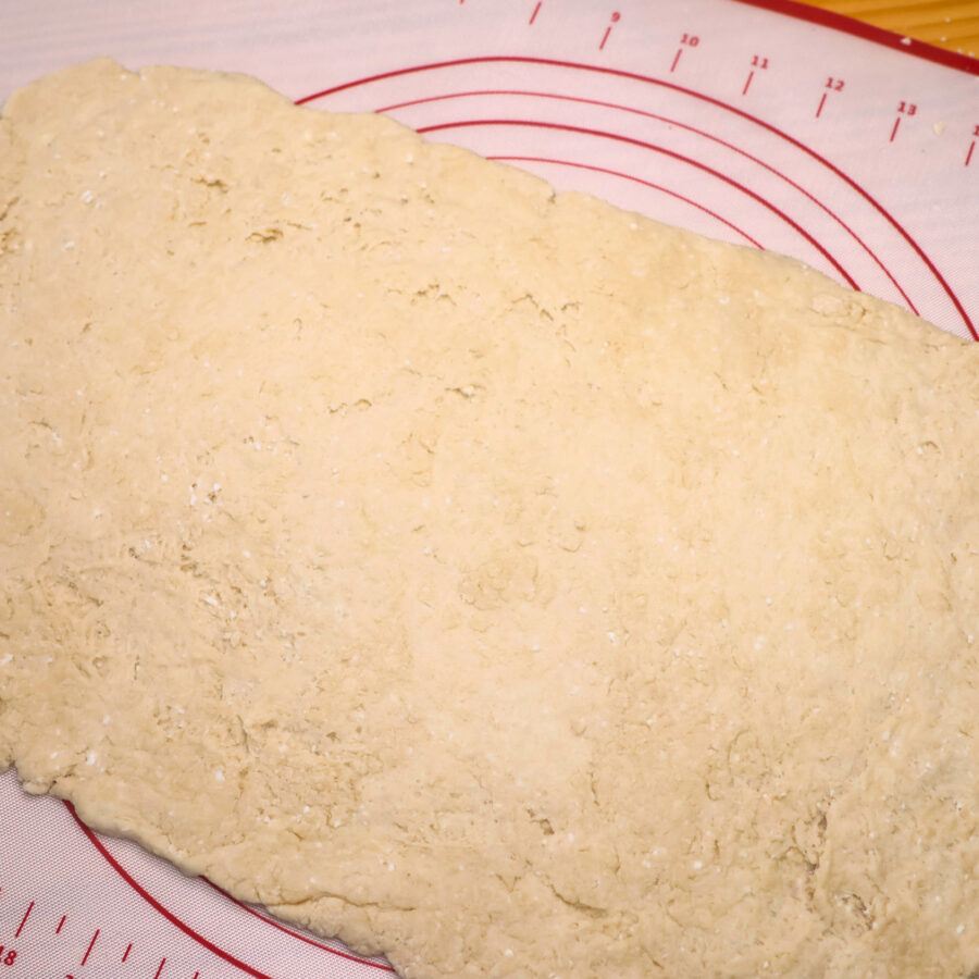 Cottage cheese cinnamon roll dough rolled out on a silicone mat