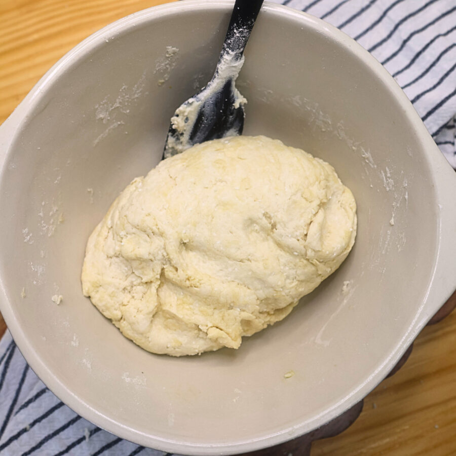 dough for cottage cheese flatbread in a bowl with a black spatula