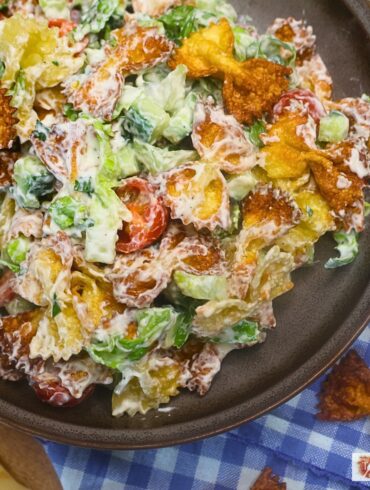 Overhead image of Crispy Pasta salad in a bowl with blue gingham cloth in the background