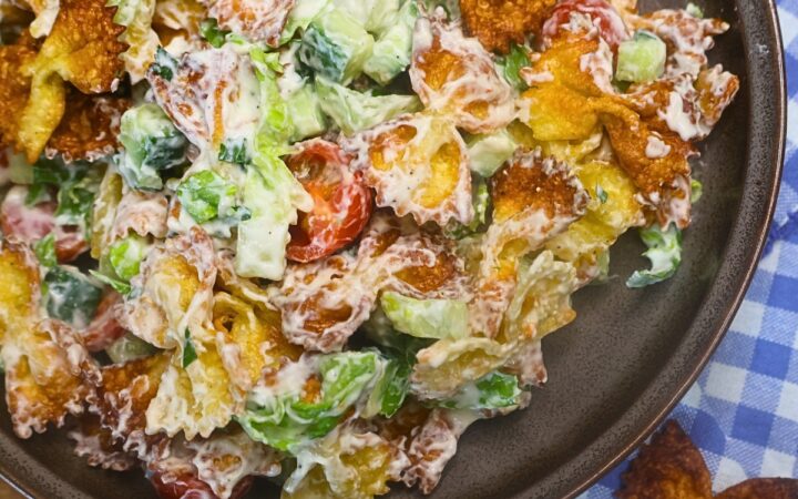 Overhead image of Crispy Pasta salad in a bowl with blue gingham cloth in the background