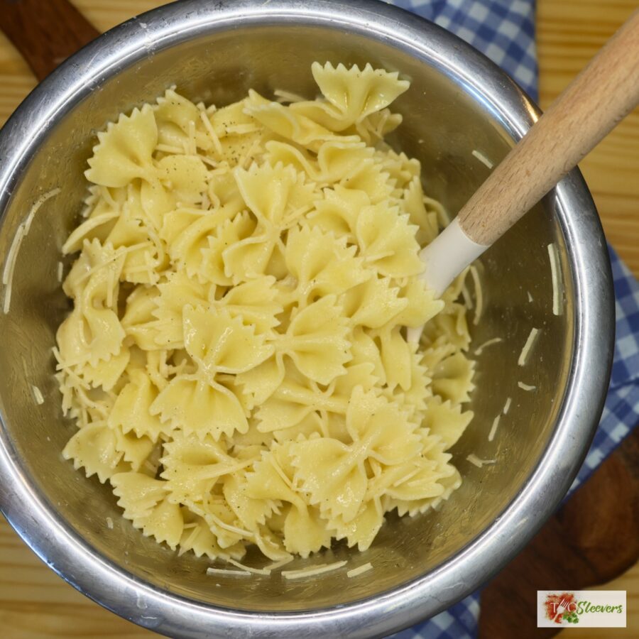 Cooked bowtie pasta seasoned with parmesan cheese in a bowl 