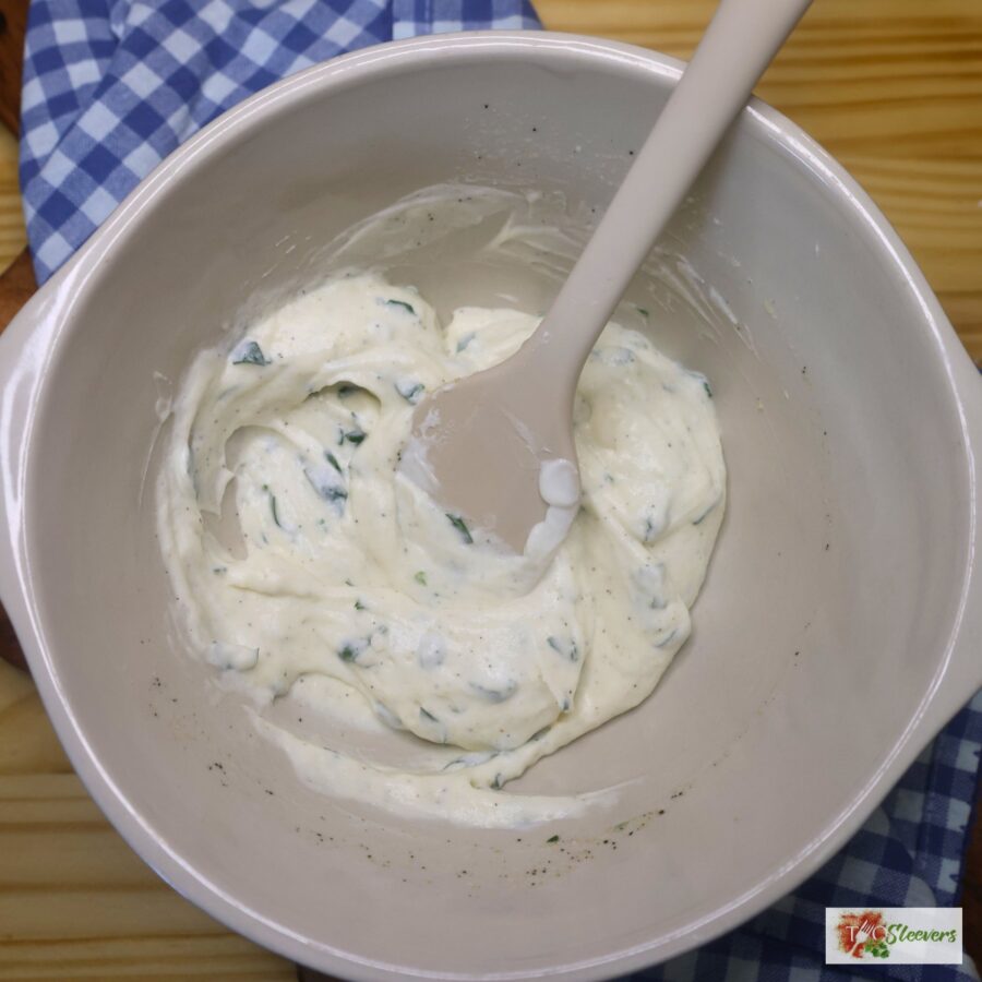 Dressing for crispy pasta salad being stirred in a large bowl with a silicone spatula