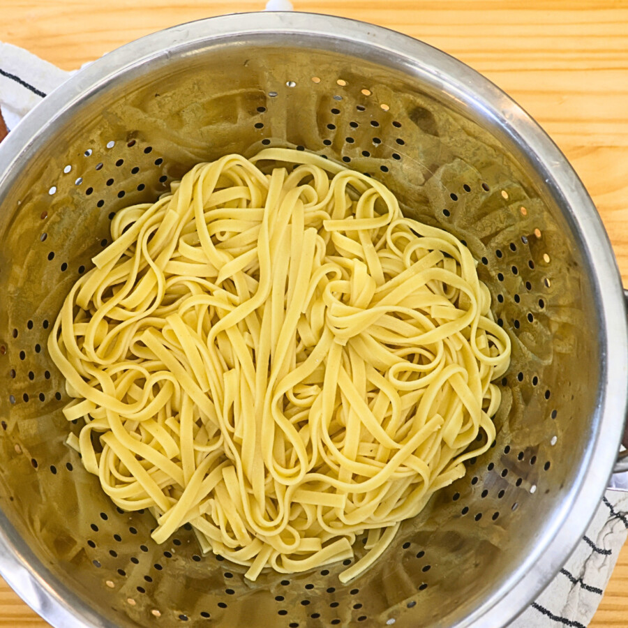 Cooked fettuccine noodles in a collander