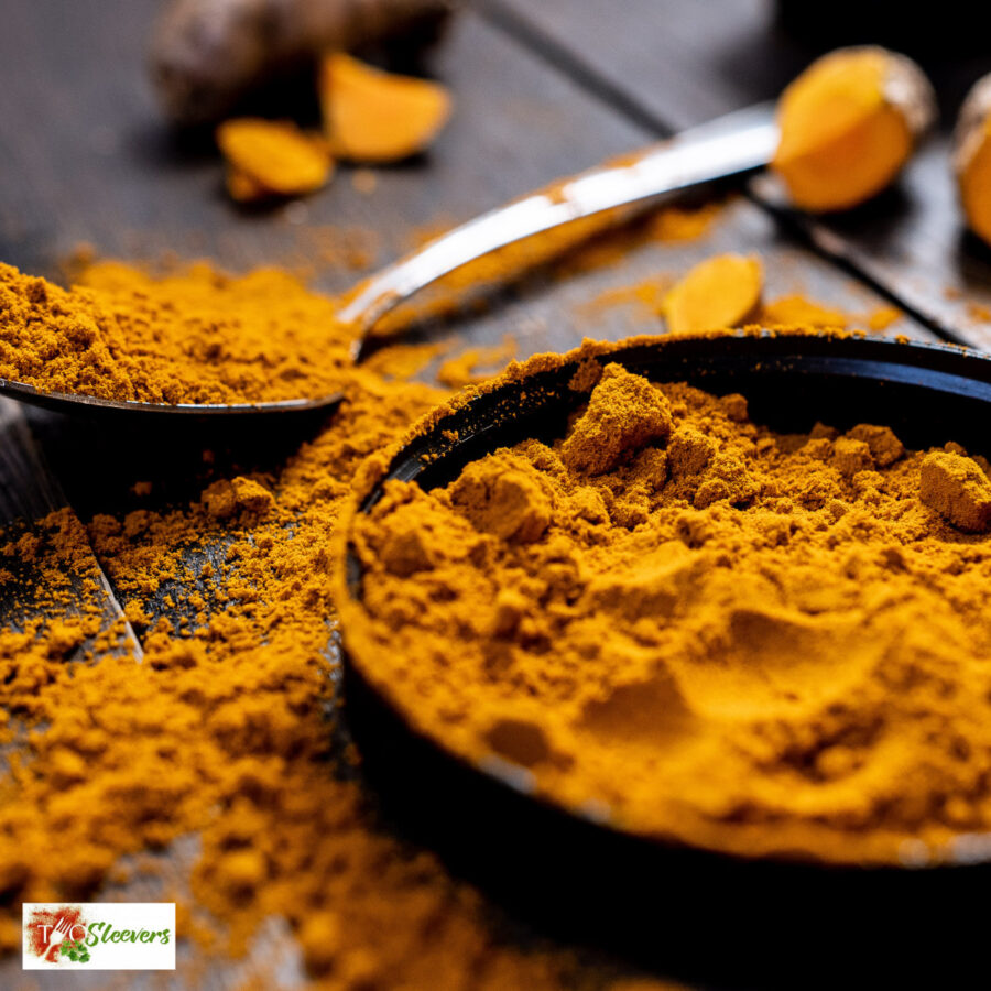 Curry powder in a bowl and scattered on a table with a spoon