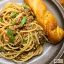 A serving of dirty spaghetti on a plate with garlic bread
