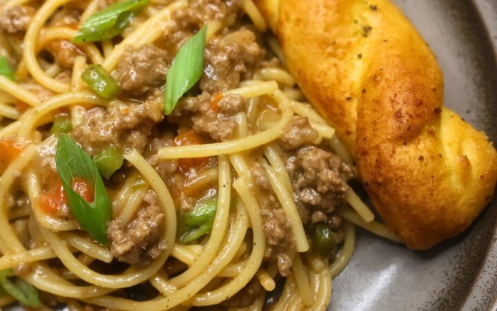 A serving of dirty spaghetti on a plate with garlic bread