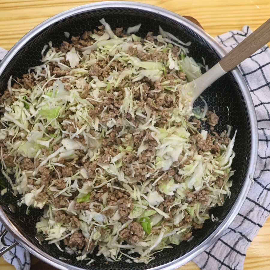 Cooked pork with shredded cabbage in a skillet
