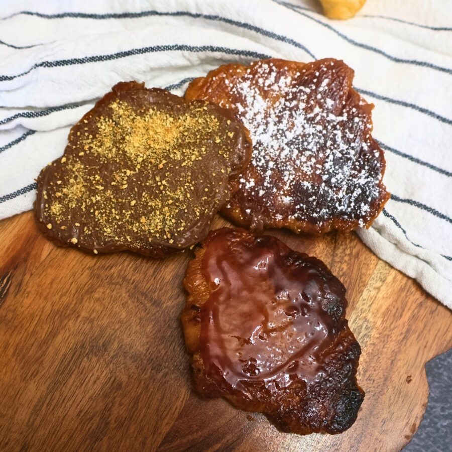 Three flat croissants with a variety of toppings