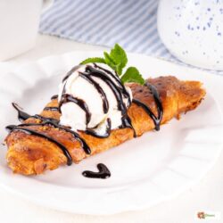 A flat croissant with chocolate drizzle