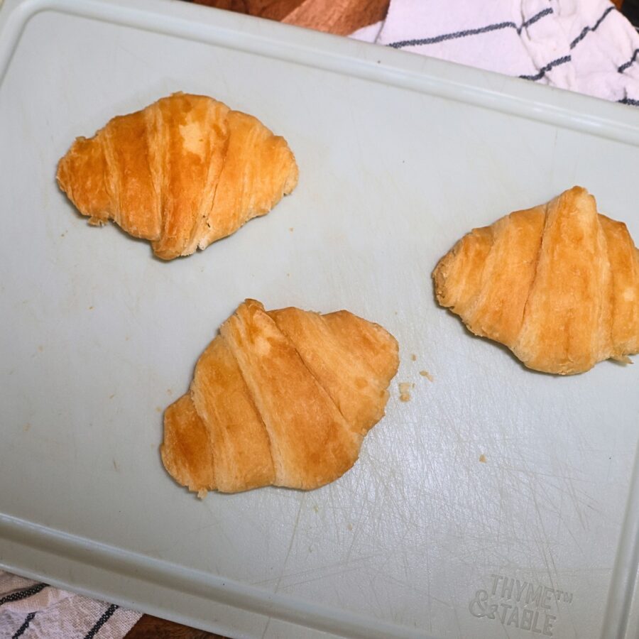 Mini croissants pressed flat on a cutting board