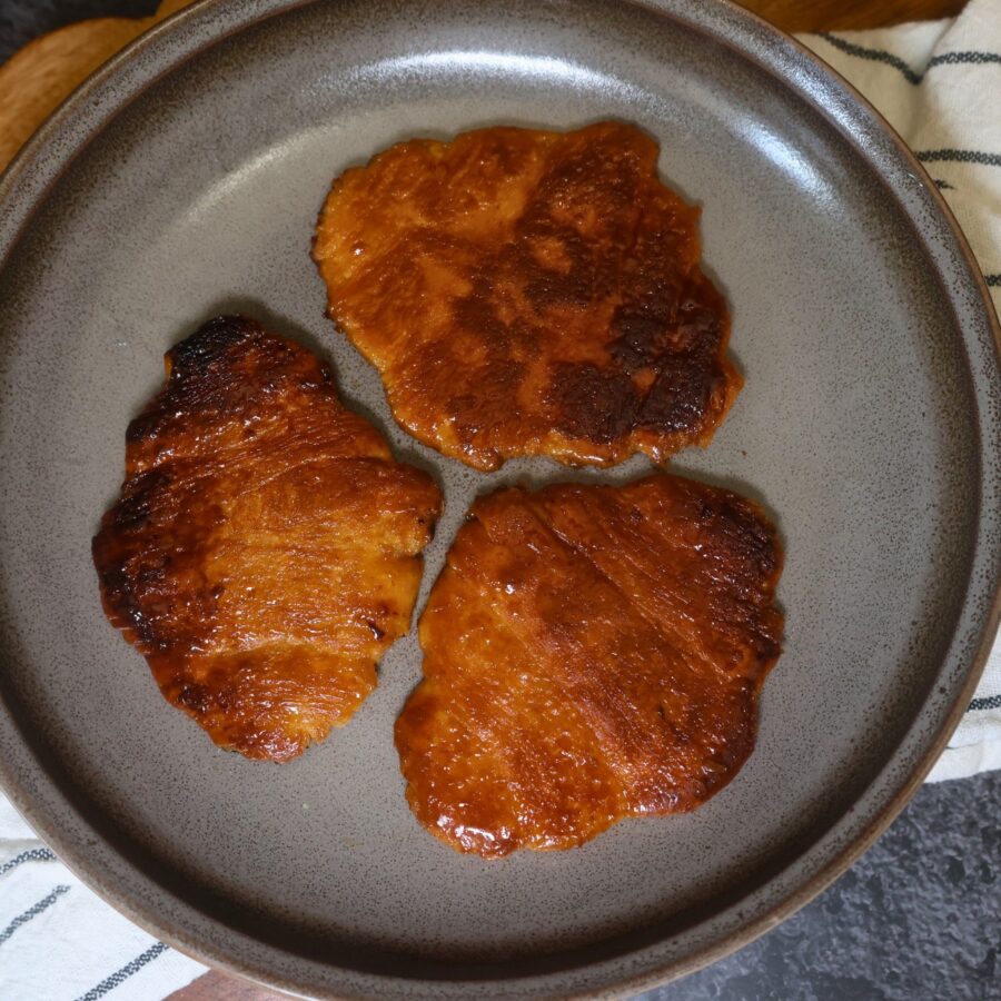 Three cooked flat croissants on a plate