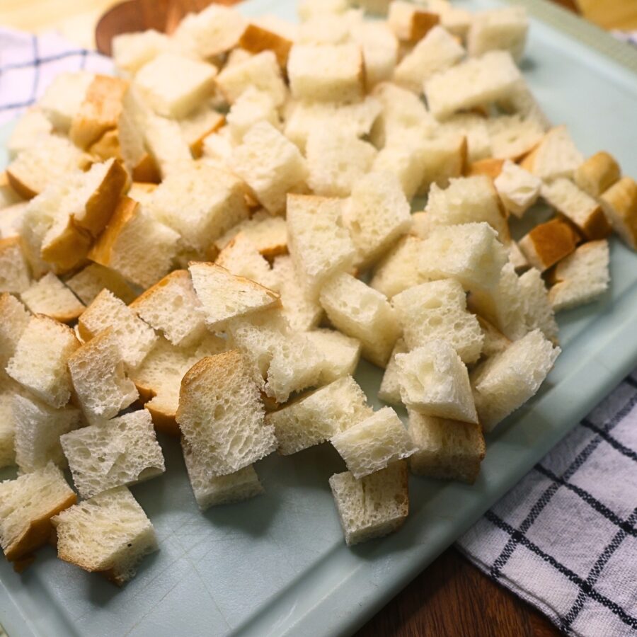 Cubed French bread on a cutting board