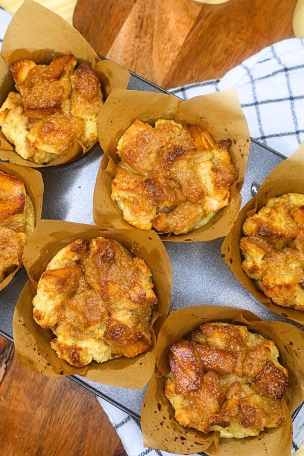 Six French Toast Muffins in a baking tin on a rustic backdrop