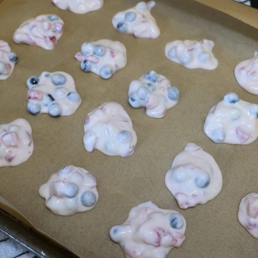 Sweetened Greek yogurt and chopped berries scooped into small mounds on parchment paper