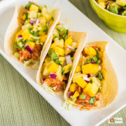 Fast food Overhead image of three Instant Pot Hawaiian Chicken Tacos on a white plate