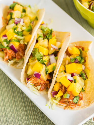 Overhead image of three Instant Pot Hawaiian Chicken Tacos on a white plate