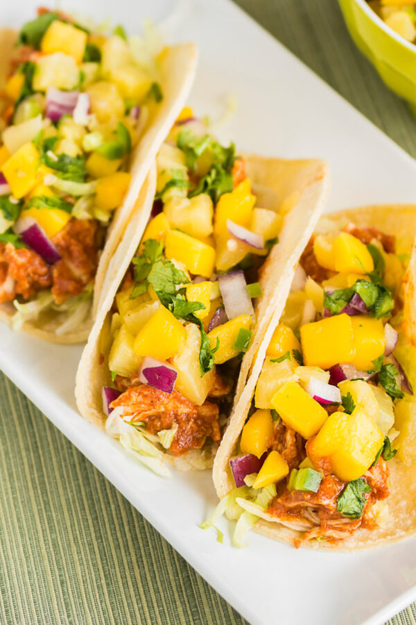 Overhead image of three Instant Pot Hawaiian Chicken Tacos on a white plate