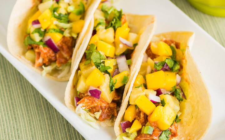 Overhead image of three Instant Pot Hawaiian Chicken Tacos on a white plate