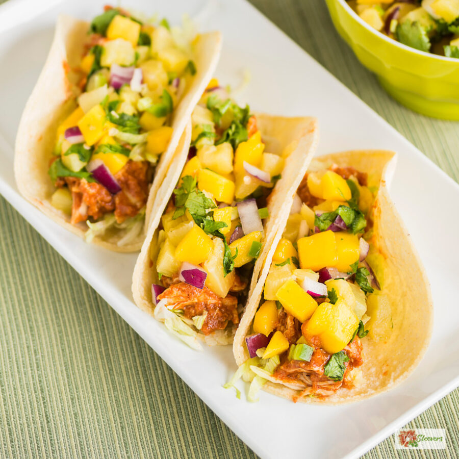Overhead image of three Instant Pot Hawaiian Chicken Tacos on a white plate