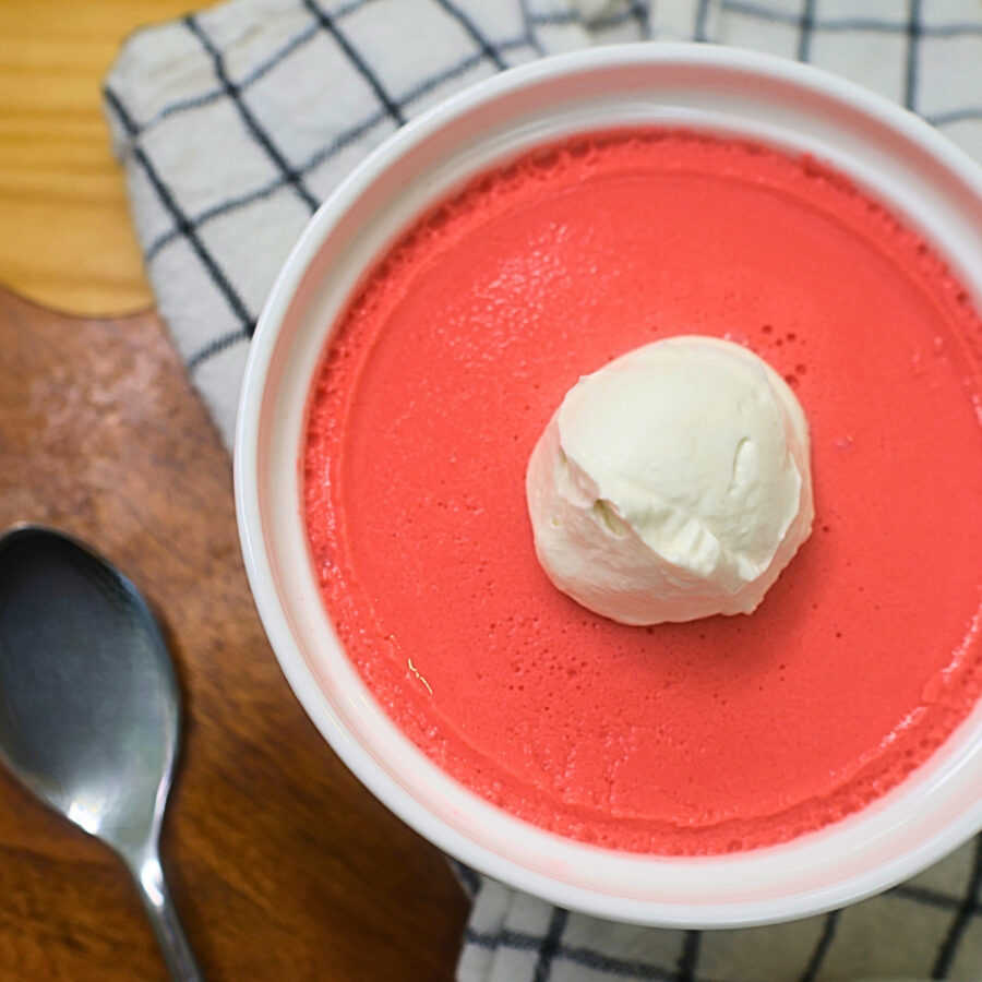 Close up image of high protein jello mousse with whipped topping in a white ramekin