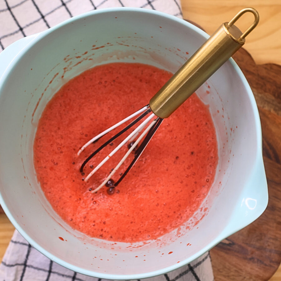 Sugar Free Jello being dissolved in hot water in a blue bowl with a whisk