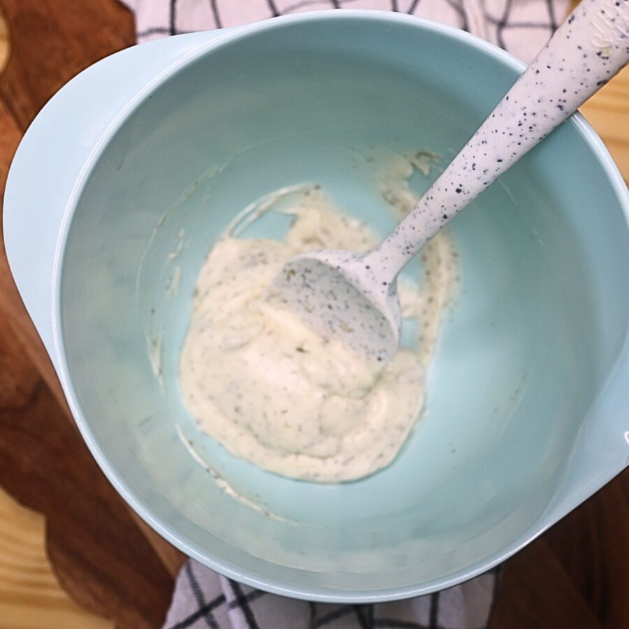 Homemade mayo dressing for hoagie dip in a mixing bowl with a spatula
