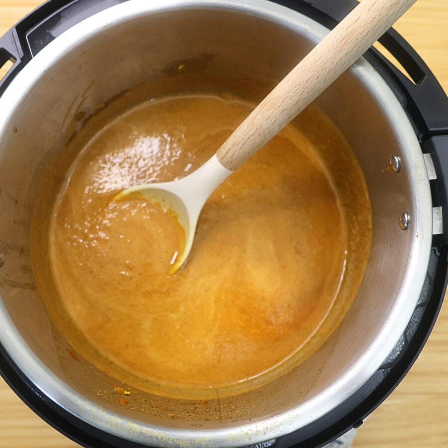 Sauce in an Instant Pot liner with half and half added and a spoon inside