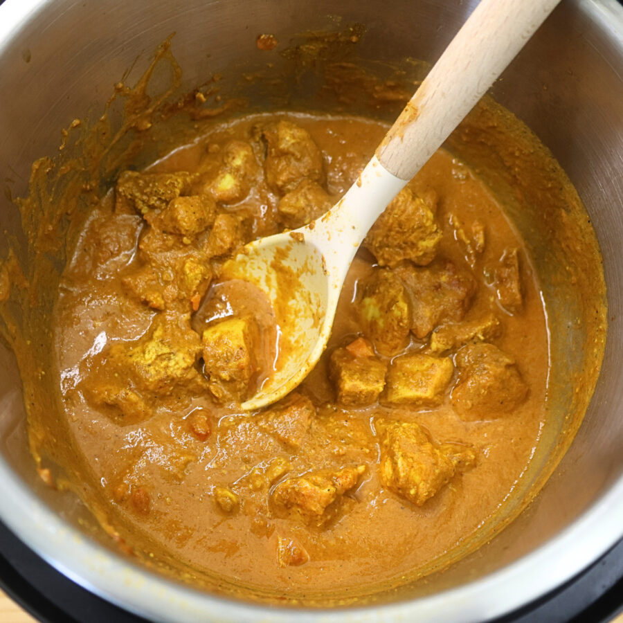 Instant Pot Chicken Tikka Masala in a pressure cooker with a spoon
