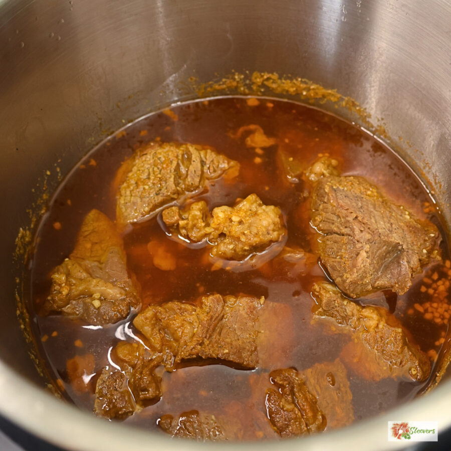 Cooked chuck roast in an Instant Pot liner with homemade Korean sauce