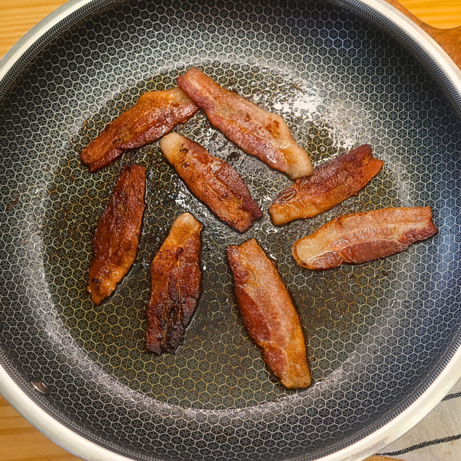 Bacon being fried in a skillet