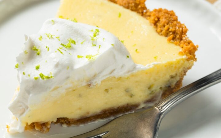 A slice of Key Lime Pie on a plate with a fork