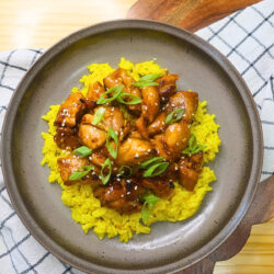 Overhead image of air fryer Korean BBQ chicken over a bed of yellow rice on a plate