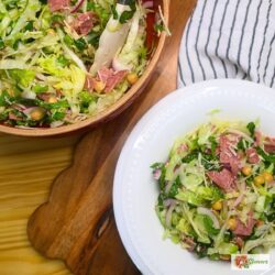 Chopped A bowl of la scala salad next to the mixing bowl of prepared salad