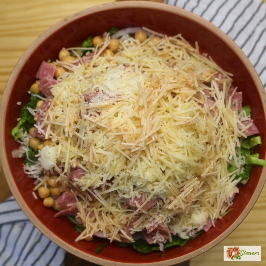 Assembled la scala salad in a red bowl before being tossed