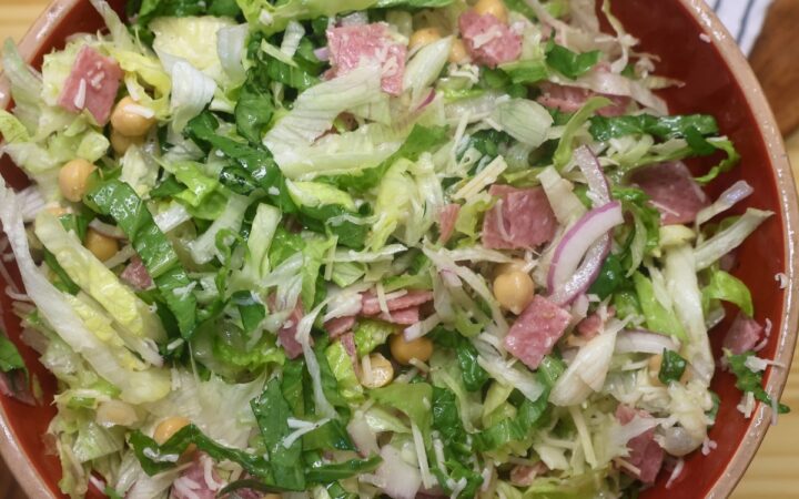 Overhead image of a tossed la scala salad in a red bowl